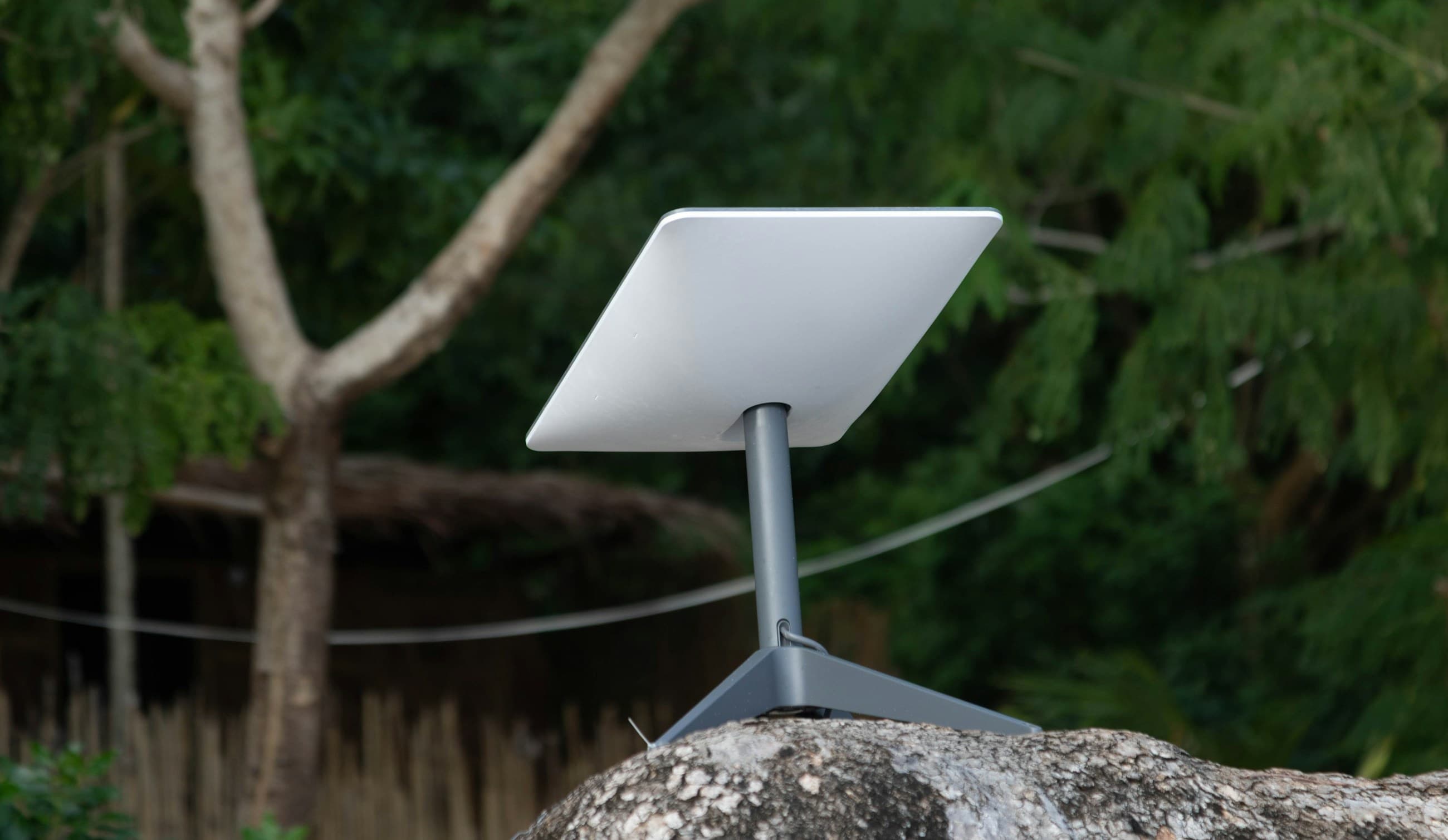 A Starlink Mini dish set up outdoors on a rock